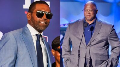 Randy Moss posing in suit and Larry Fitzgerald Sr on stage