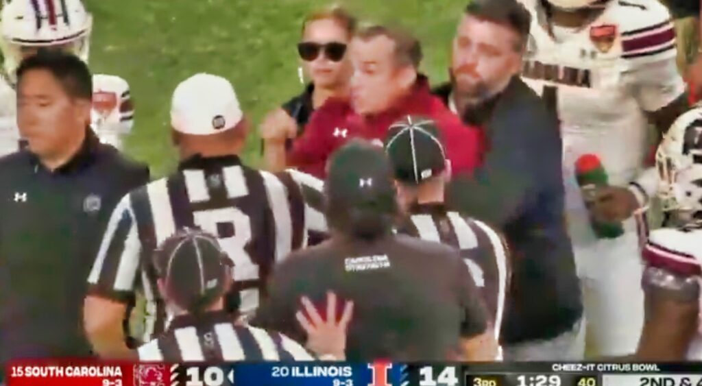 South Carolina Gamecocks head coach Shane Beamer being held back.