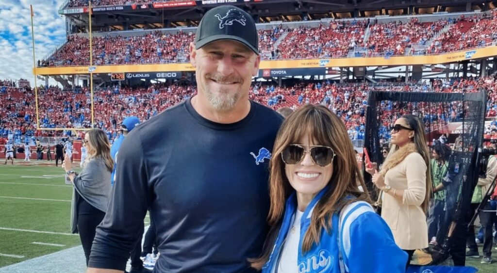 Dan Cambell and Holly posing on field