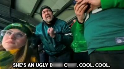 Eagles fan and Packers fan in stands