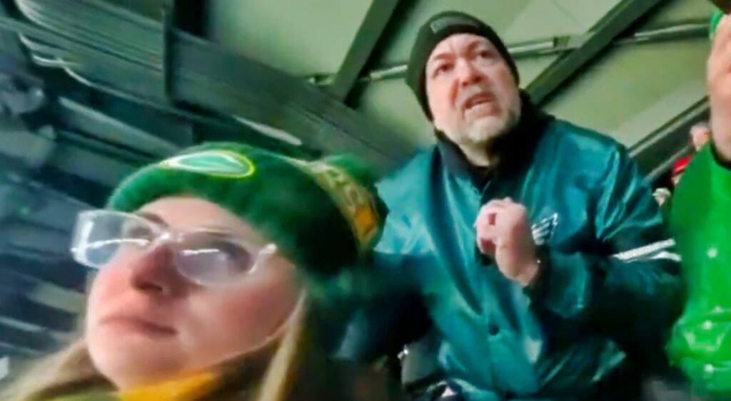 Eagles fan and female packers fan in stands