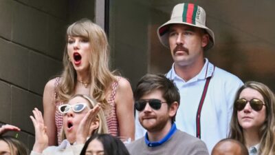 Taylor Swift sitting next to Travis Kelce