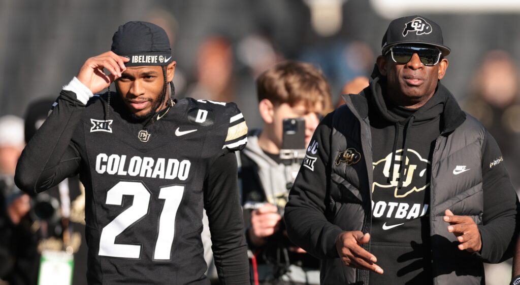 Shilo Sanders and Deion Sanders look on at game.