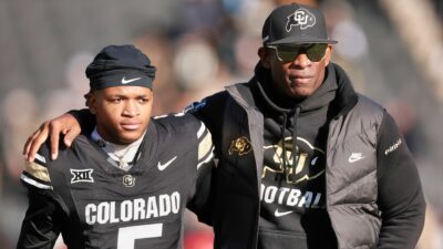 Dion Sanders holding Jimmy Horn Jr.