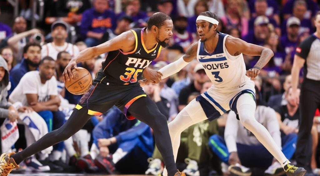 Kevin Durant of the Phoenix Suns handles the ball against Jaden McDaniels of the Minnesota Timberwolves