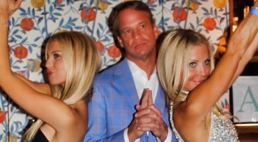 Lane Kiffin standing between two ladies