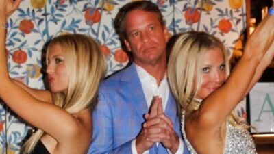 Lane Kiffin standing between two ladies