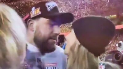 Travis Kelce and Taylor Swift looking at each other before a kiss