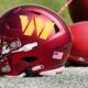 Washington Commanders helmet and football on field