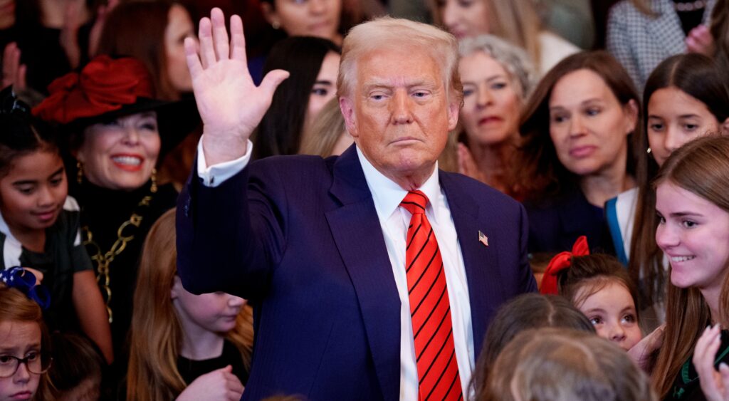 Donald Trump waving with kids around him