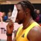 Noah Lyles on track holding paper