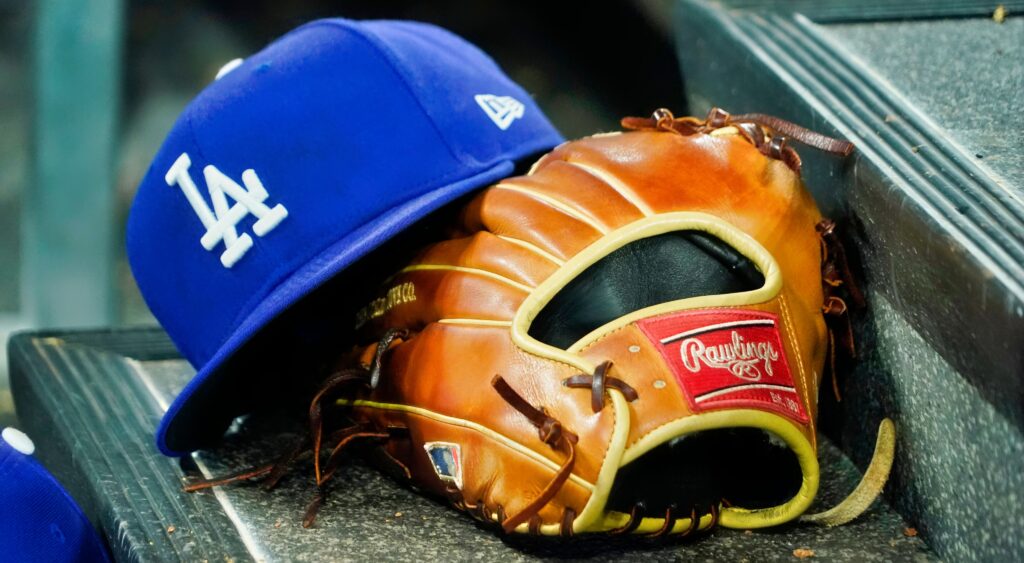 Los Angeles Dodgers hat and glove on the bench.